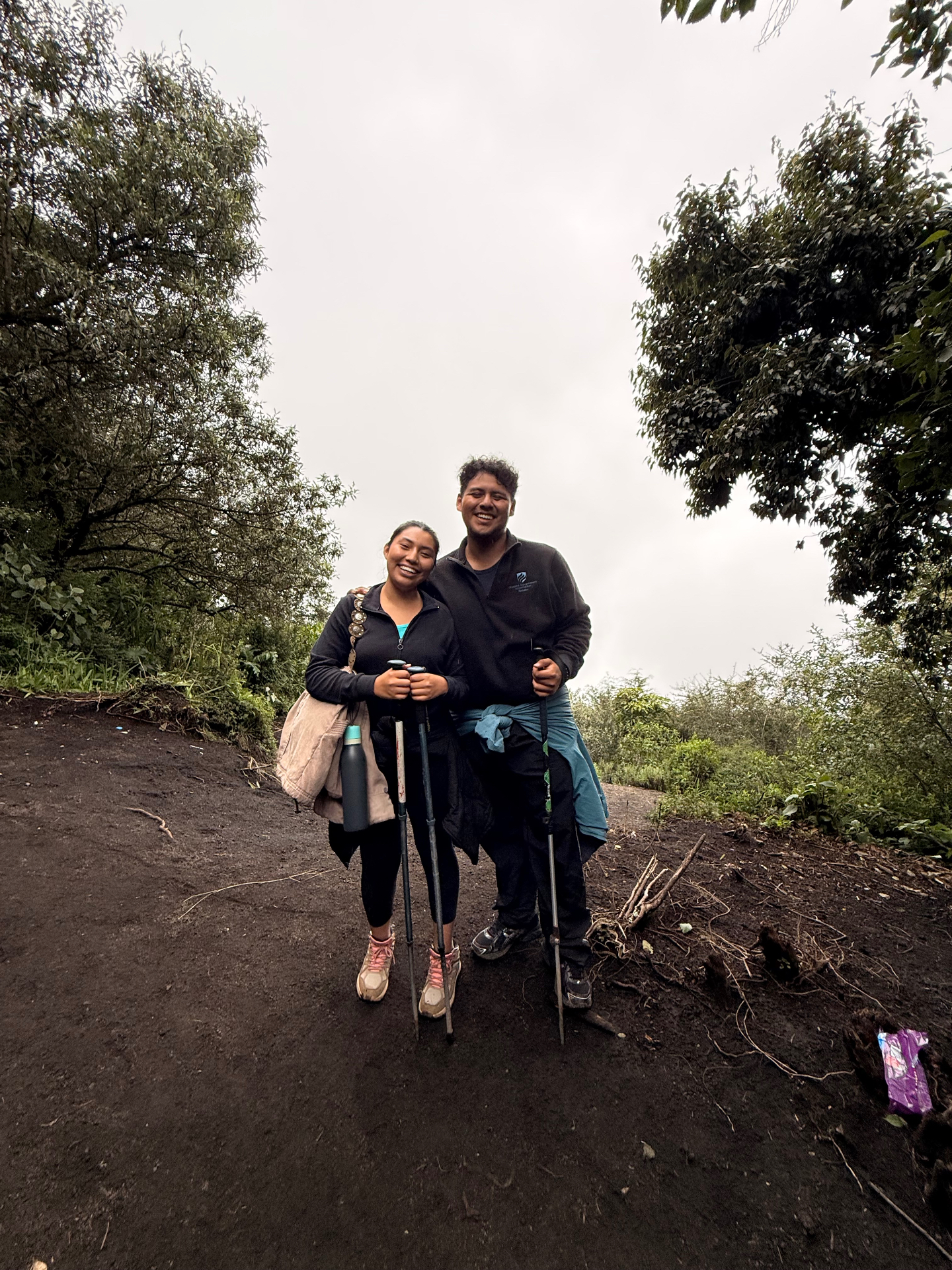 Chris Guzaro and Ivon hiking up Volcán Acatenango with trekking poles